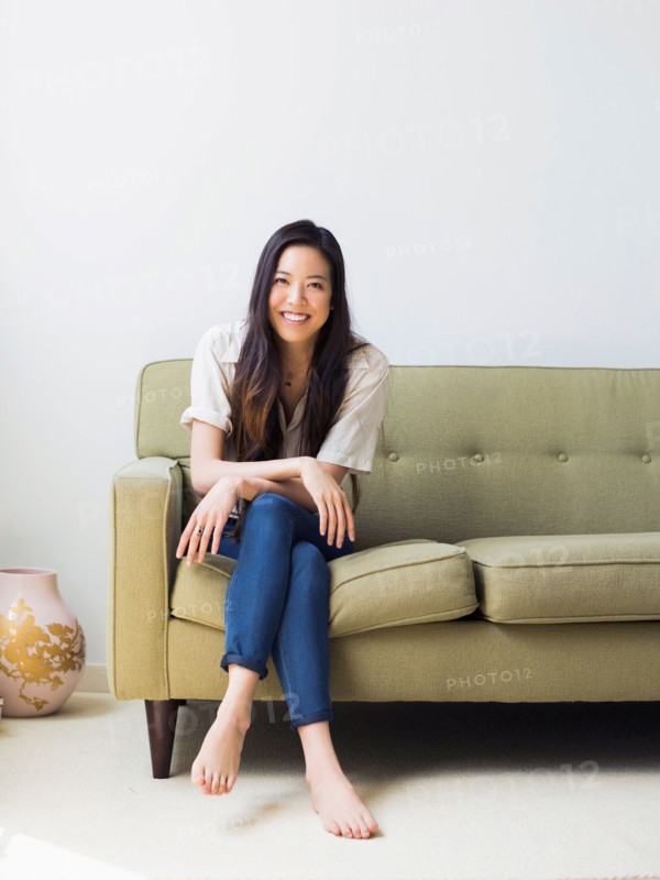 Portrait of happy young woman sitting on sofa