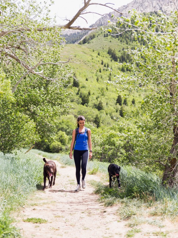 Woman with two dogs hiking in landscape