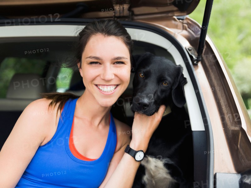 Woman sitting in car with dog