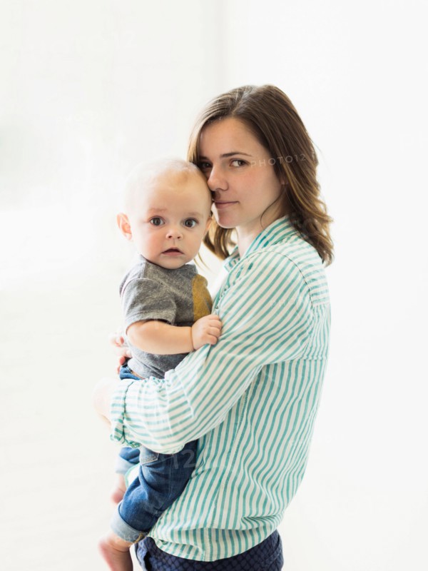 Mother holding baby boy (6-11 months) indoors