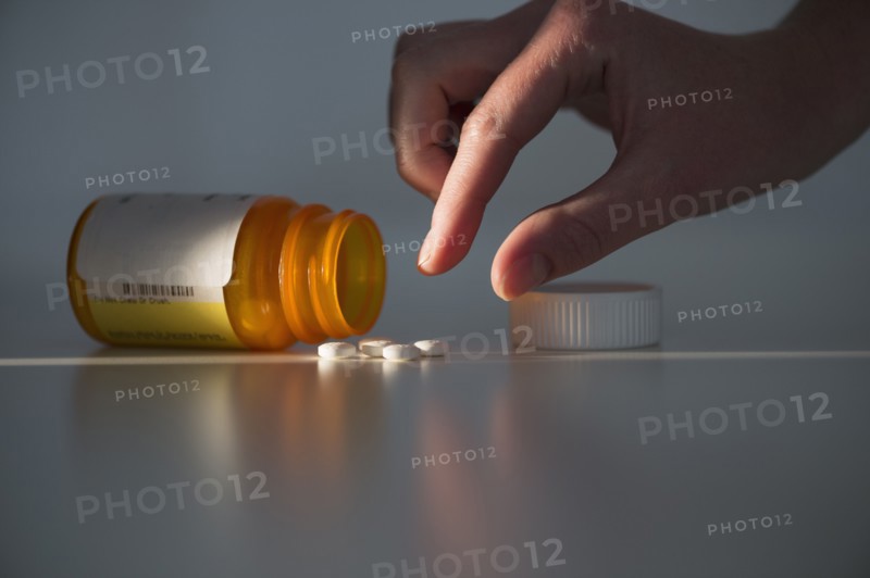 Studio shot of hand reaching for pill.