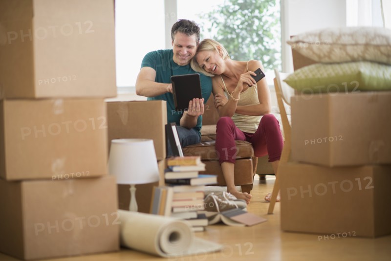Couple using tablet pc in new home.
