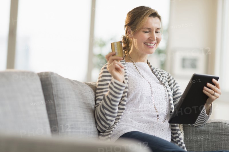 Woman holding tablet pc and credit card.