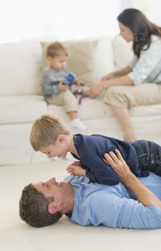 Parents with kids (12-17 months, 6-7) playing at home.
