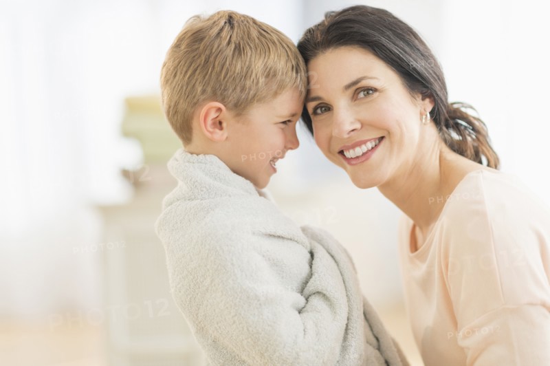 Mother with son (6-7) wrapped in towel.