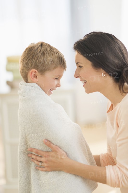 Mother with son (6-7) wrapped in towel.