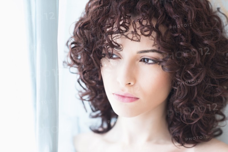 Beautiful woman looking through window.