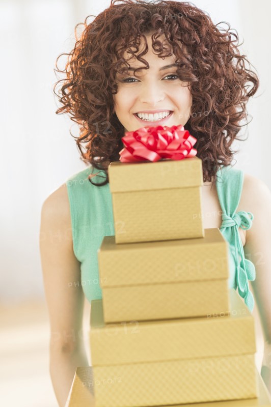 Woman holding stack of gifts.