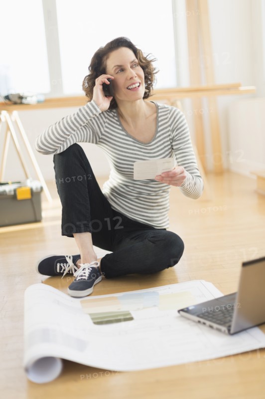 Woman talking on cell phone and using laptop.