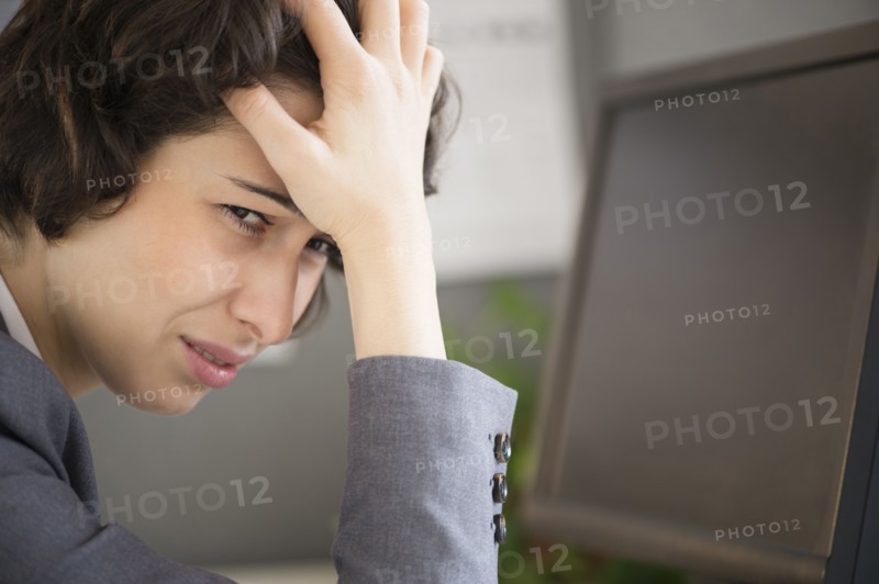 Businesswoman with head in hands.
Photo : Jamie Grill