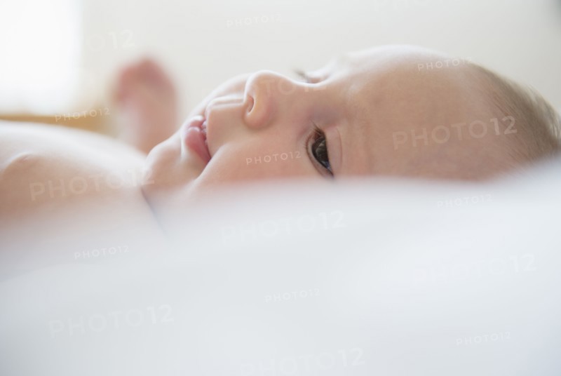 Baby girl (2-5 months) lying on bed.
Photo : Jamie Grill
