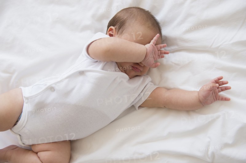 Baby girl (2-5 months) lying on bed and crying.
Photo : Jamie Grill