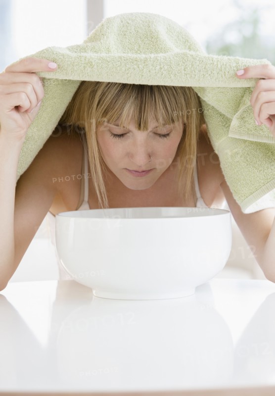 Woman inhaling steam from bowl.
Photo : Jamie Grill