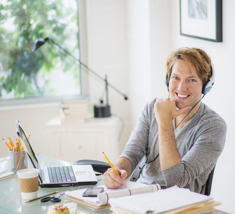 Portrait of man multi-tasking in home office.
Photo : Daniel Grill