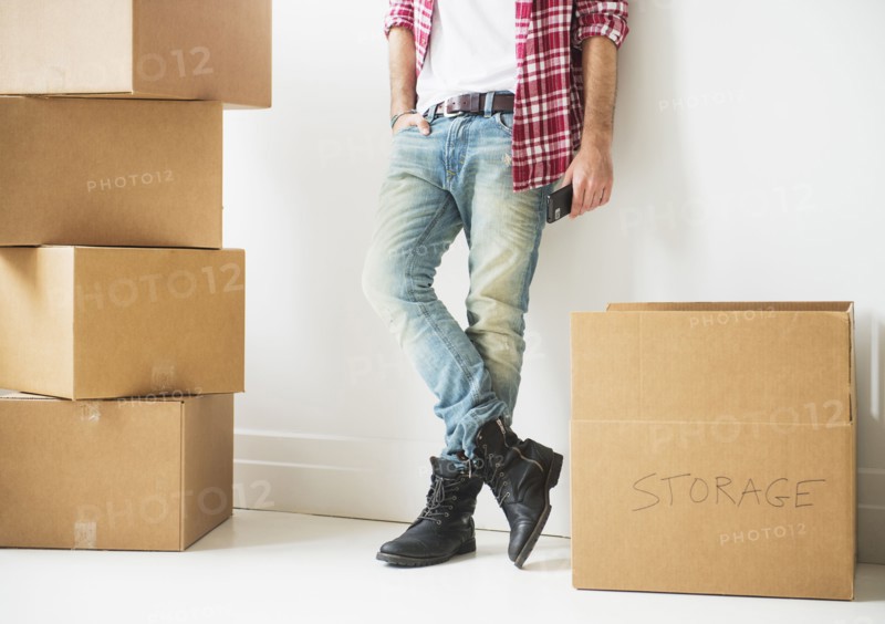 Low section of man next to stack of cardboard boxes.
Photo : Daniel Grill