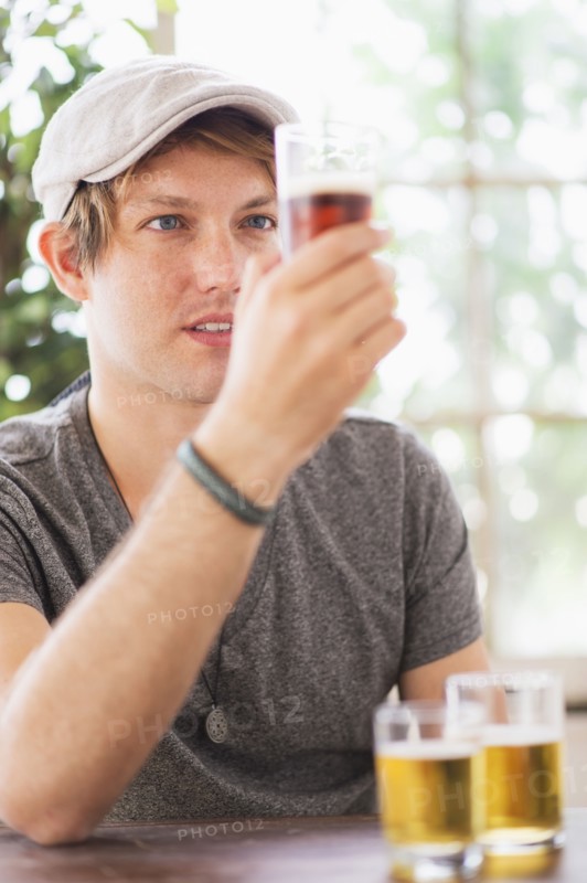 Man looking at glass of beer.
Photo : Daniel Grill