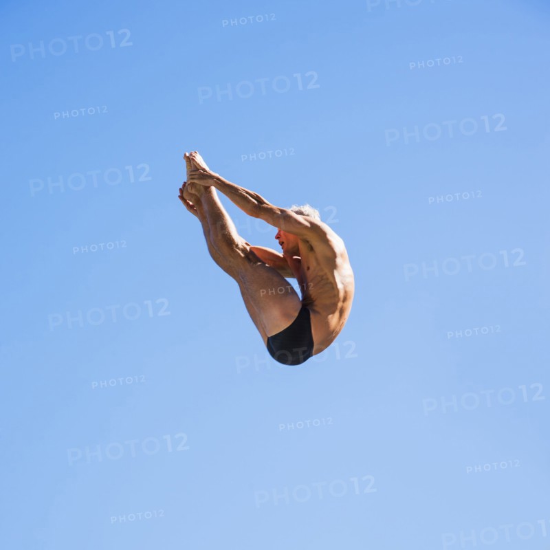 Athletic swimmer mid-air against blue sky.
Photo : Daniel Grill