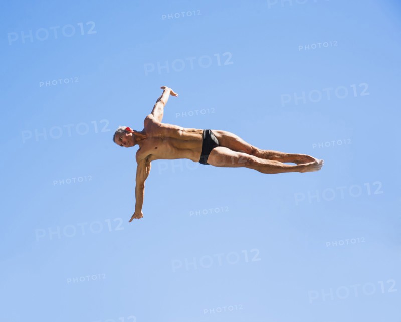 Athletic swimmer mid-air against blue sky.
Photo : Daniel Grill