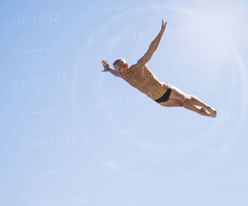 Athletic swimmer mid-air against blue sky.
Photo : Daniel Grill