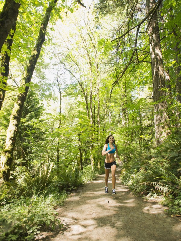 Young woman jogging in forest. USA, Oregon, Portland.