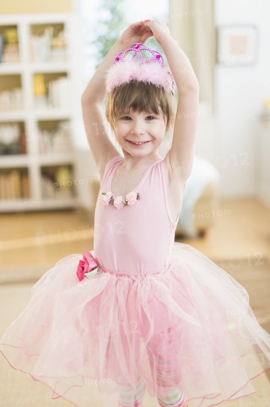 Girl (4-5) wearing tutu dancing in living room.