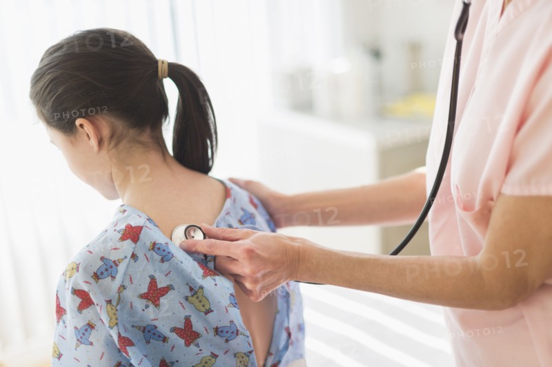 Doctor examining girl (8-9).