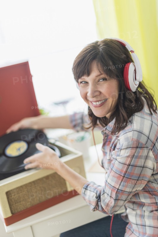 Woman listening to music on antique record player.