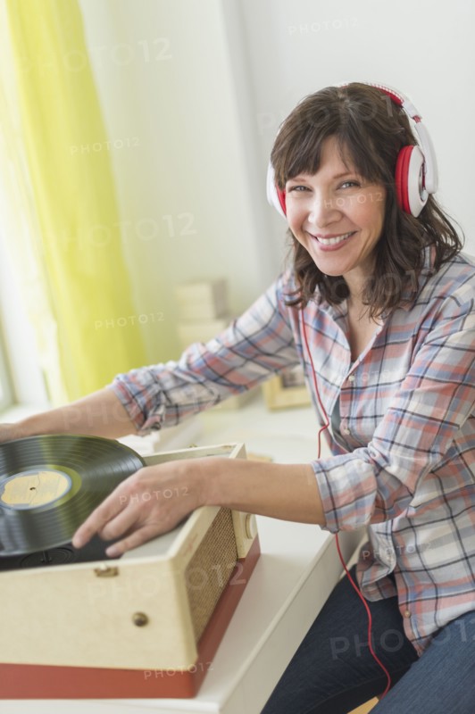 Woman listening to music on antique record player.
