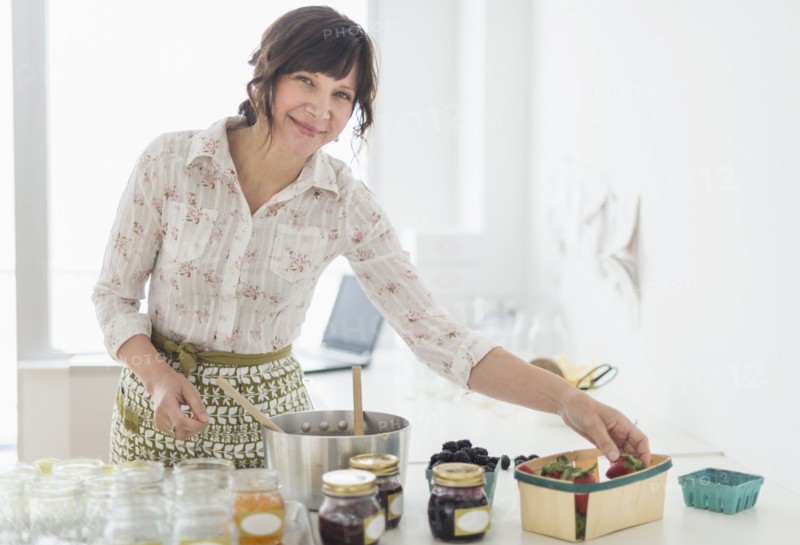 Woman making preserves in kitchen.