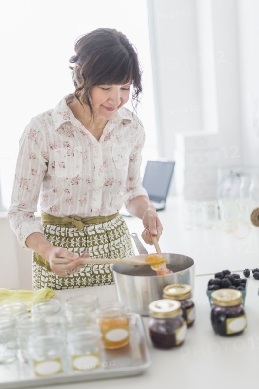 Woman making preserves in kitchen.