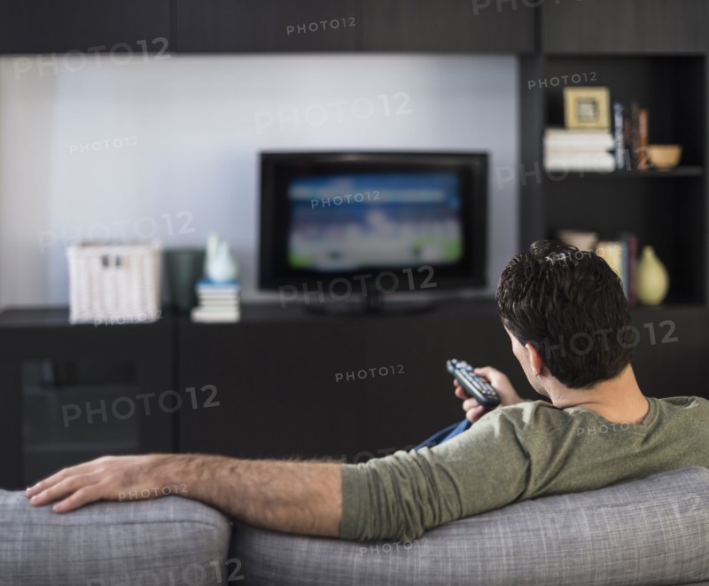 Rear view of man watching tv.