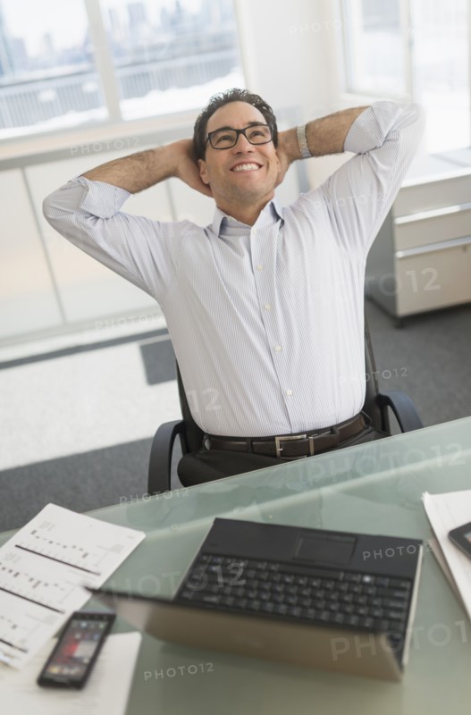 Businessman using laptop and digital tablet.