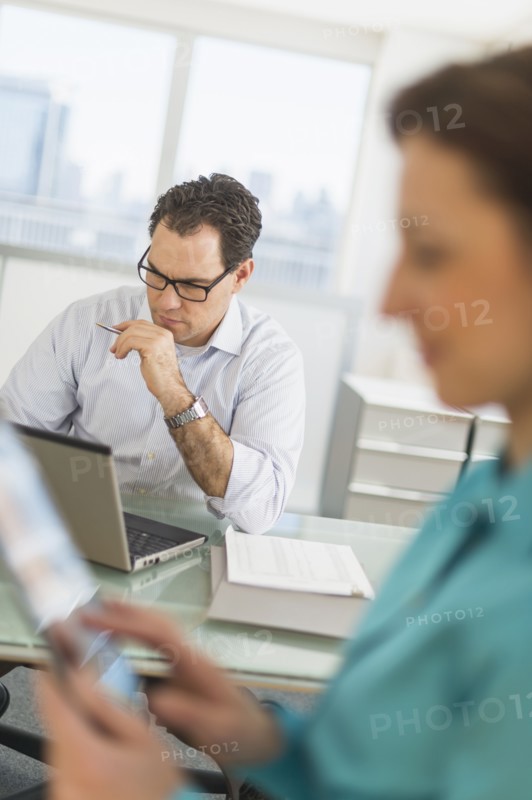 Businessman and businesswoman working in office.