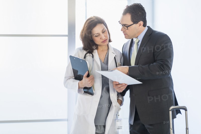 Pharmaceutical representative talking to female doctor.