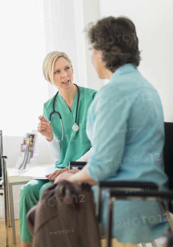 Doctor talking to patient in waiting room.