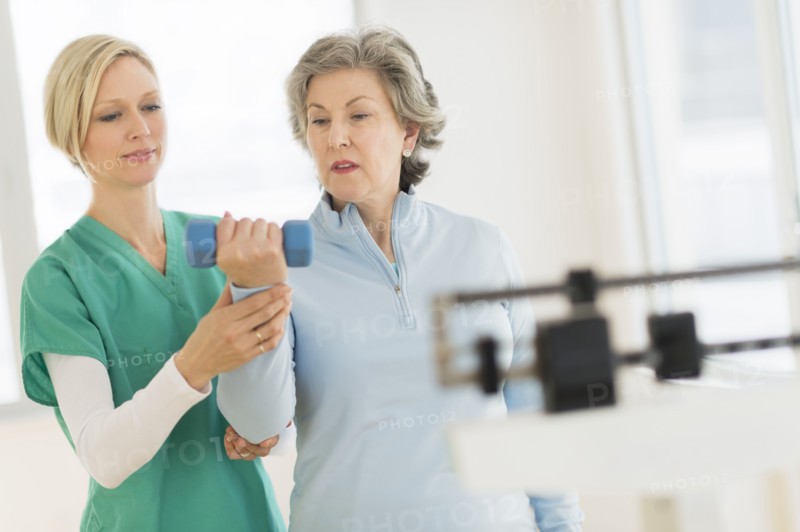 Mature woman exercising with personal trainer.