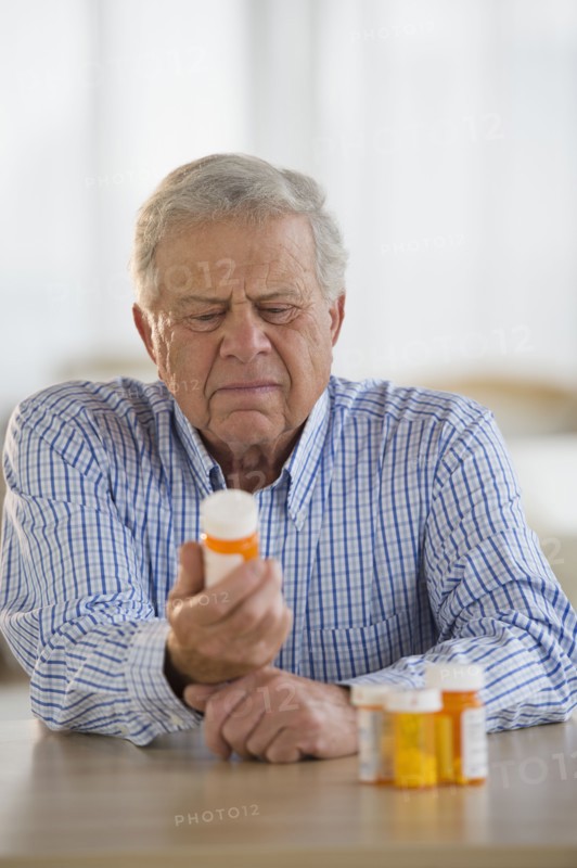 Senior man holding pill bottle.
Photo : Jamie Grill