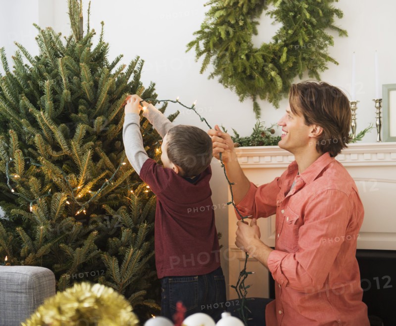 Man with kid (6-7) decorating Christmas tree.
Photo : Daniel Grill