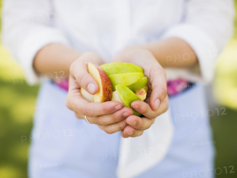 Woman holding sliced apple.
Photo : Jessica Peterson