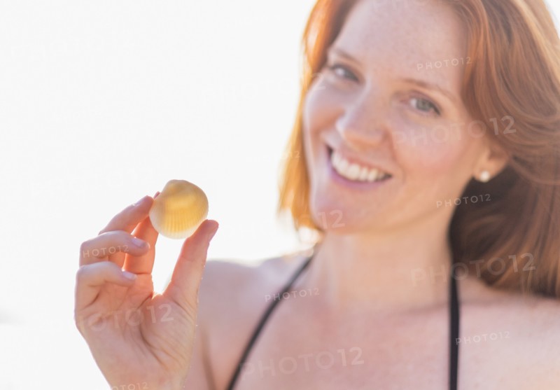 Portrait of woman holding shell.