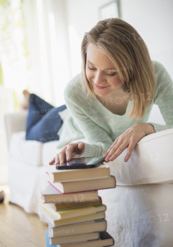Woman lying on sofa and using digital tablet.