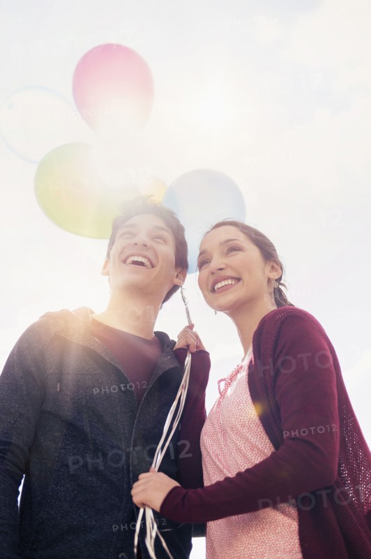 Young couple with balloons.