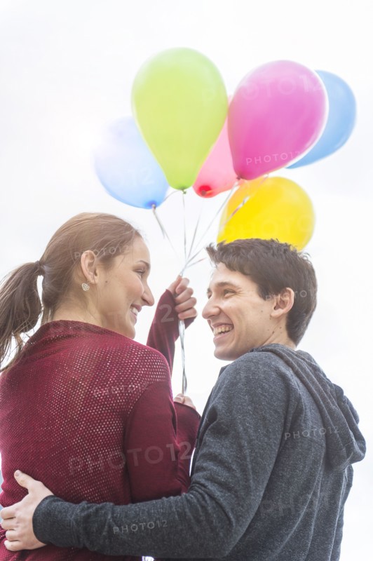 Young couple with balloons.