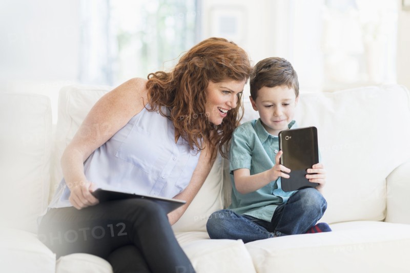 Mother and son (6-7) using digital tablet.