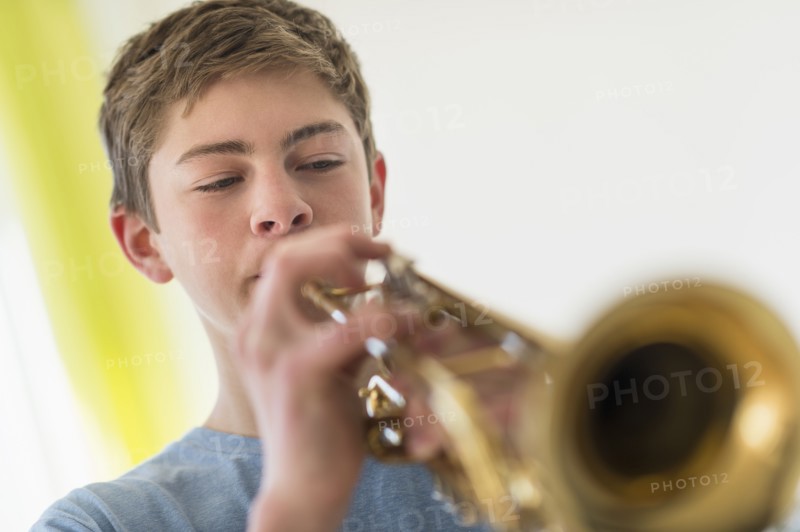 Teenage boy (16-17) playing trumpet.