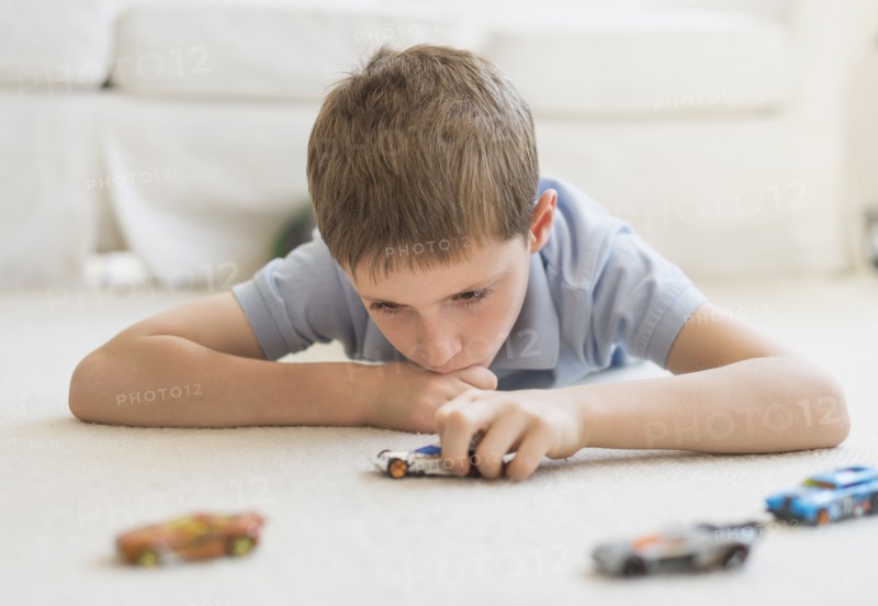 boy (8-9) playing with toy cars.