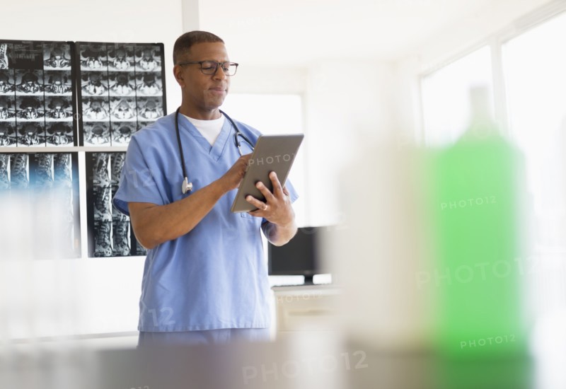 Male doctor in hospital using digital tablet.