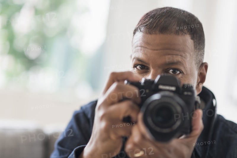 Portrait of man holding digital camera.