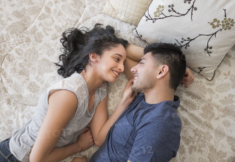 Young couple lying on bed.
