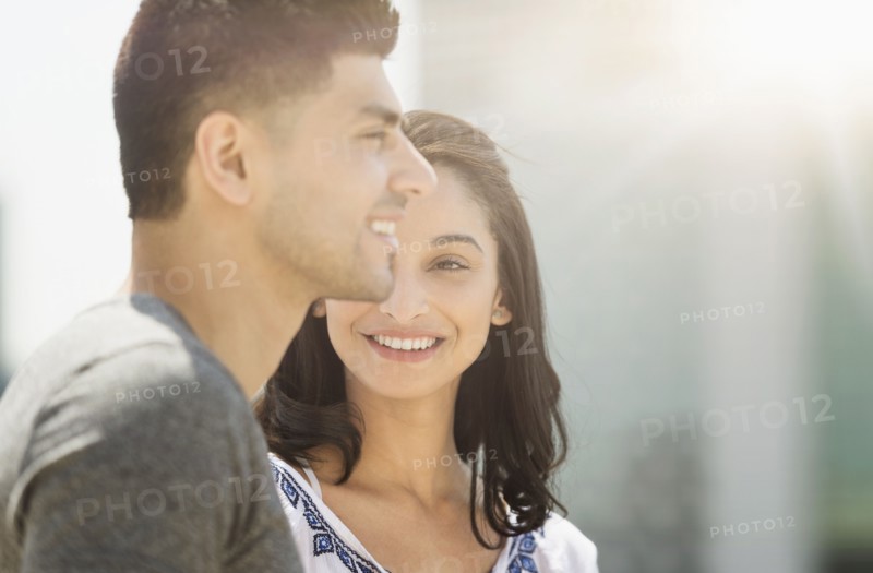Young couple smiling in sunlight.